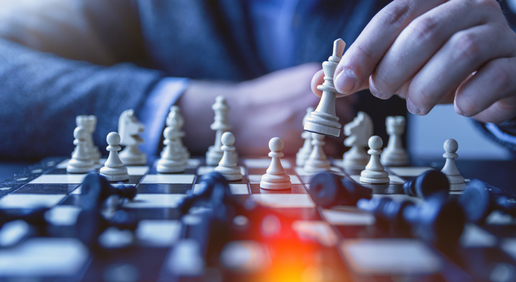 Photo of someone moving chess pieces on a board