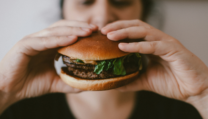 Photo of a person eating a beefburger